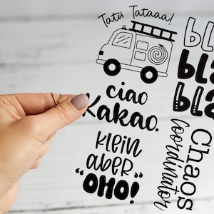Könnte beinhalten: Ein klarer Aufkleber mit schwarzem Text und einem Cartoon-Feuerwehrwagen. Der Text enthält "Tati Tataaa!", "ciao Kakao", "klein aber .. OHO!", "bla" und "Chaos coordinator".