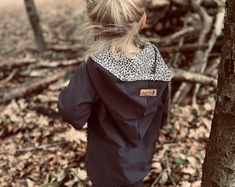 May include: A black hooded jacket with a brown and white animal print lining. The jacket has a zipper closure and a small brown label with the text "Little Monkey" on the front.