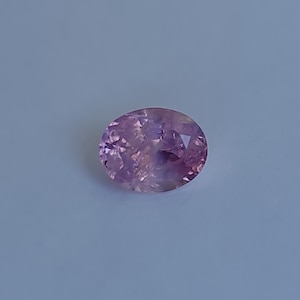 May include: A light purple oval-shaped gemstone with a faceted cut.