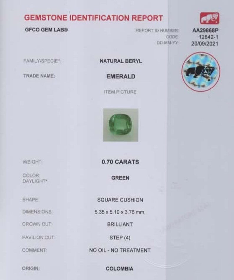 Puede incluir: Un informe de identificaci&oacute;n de gemas para una esmeralda de 0,70 quilates, de color verde y forma coj&iacute;n cuadrado. La esmeralda mide 5,35 x 5,10 x 3,76 mm. El informe indica que la esmeralda es natural, tiene un corte de corona brillante, un corte de pabell&oacute;n en escalera y proviene de Colombia. El informe tambi&eacute;n indica que la esmeralda no ha recibido ning&uacute;n tratamiento con aceite.