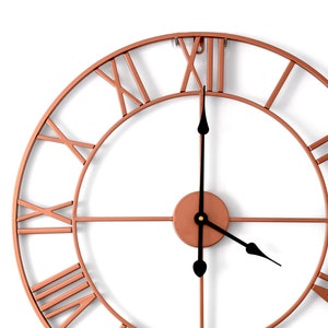 May include: A large, copper-coloured, round clock with Roman numeral markings. The clock has black hands and a simple design.