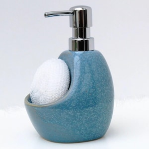 Peut inclure: Un distributeur de savon en céramique bleu avec une pompe chromée et un porte-éponge intégré. Le distributeur a un glaçage bleu moucheté.