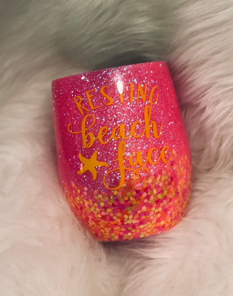 May include: Pink glitter tumbler with a gold glitter bottom and the text "Resting Beach Face" in gold lettering.