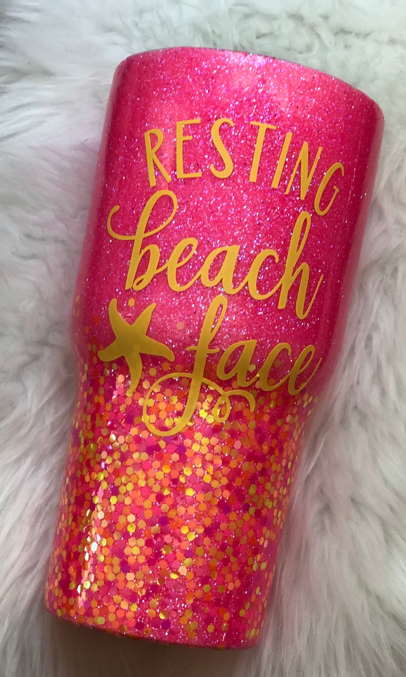 May include: Pink glitter tumbler with gold glitter accents and the text "Resting Beach Face" in gold lettering.