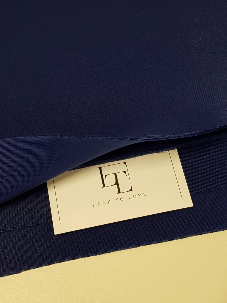 May include: A close-up of a dark blue fabric with a white tag that says "Lace to Love" in a stylized font.