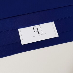 May include: A close-up of a navy blue fabric with a white card that says "Lace to Love" and has a stylized "LT" logo.
