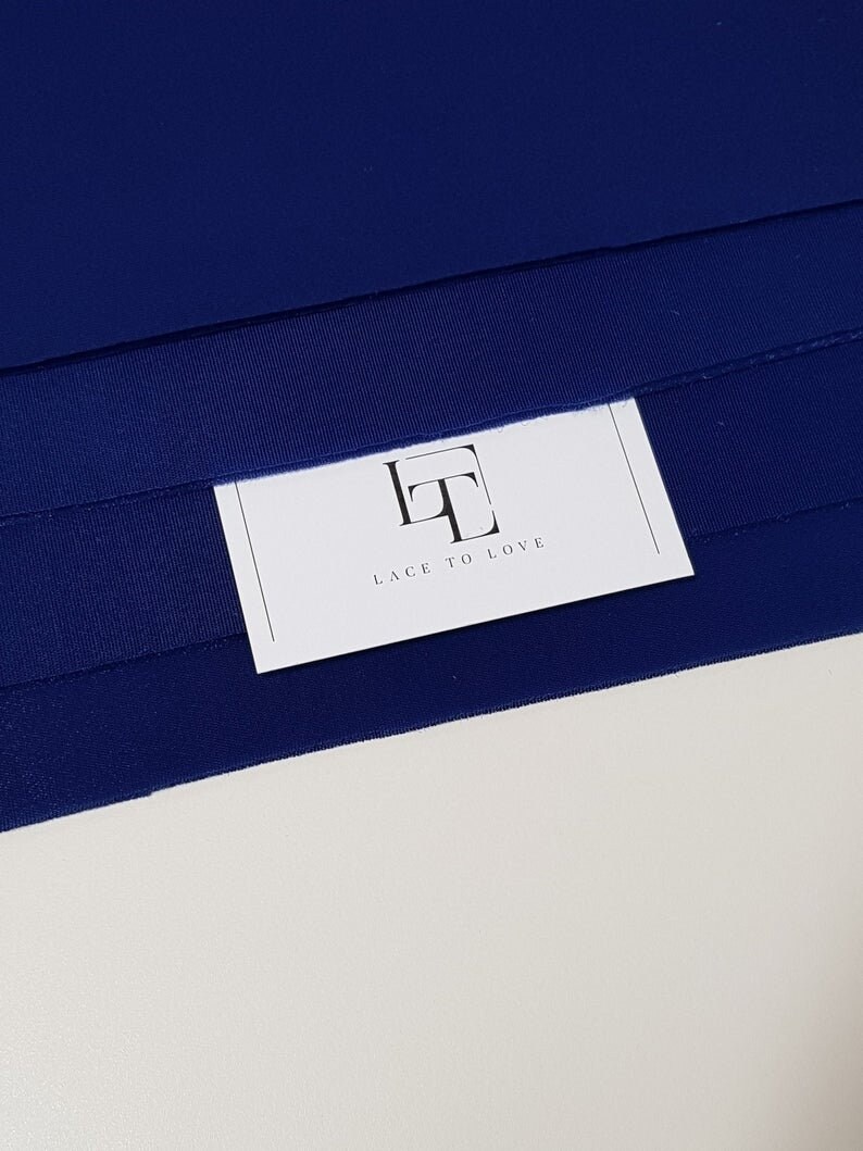 May include: A close-up of a navy blue fabric with a white card that says "Lace to Love" and has a stylized "LT" logo.
