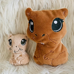 May include: Two plush toys shaped like beavers. The larger beaver is brown with black eyes and a white belly. The smaller beaver is light brown with black eyes and a white belly.