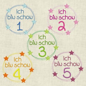 Könnte beinhalten: Fünf bunte gestickte Kreise mit Sternen drumherum. Jeder Kreis hat den Text "Ich bin scho" und eine Zahl von 1 bis 5.