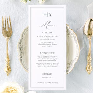 May include: Elegant wedding menu with gold cutlery, a floral plate, and white flowers. The menu features starters, main courses, and desserts, with the names of the couple and the wedding date at the bottom.