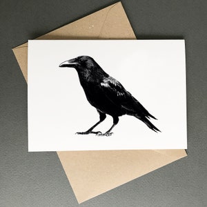 K&ouml;nnte beinhalten: Eine Schwarzwei&szlig;illustration eines Rabens mit gefalteten Fl&uuml;geln. Der Rabe blickt nach rechts und hat einen langen Schnabel.