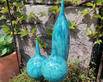 Puede incluir: Tres adornos de jardín de cerámica azul turquesa en forma de lágrima sobre estacas de metal. Los adornos están moteados de blanco y tienen un acabado brillante.