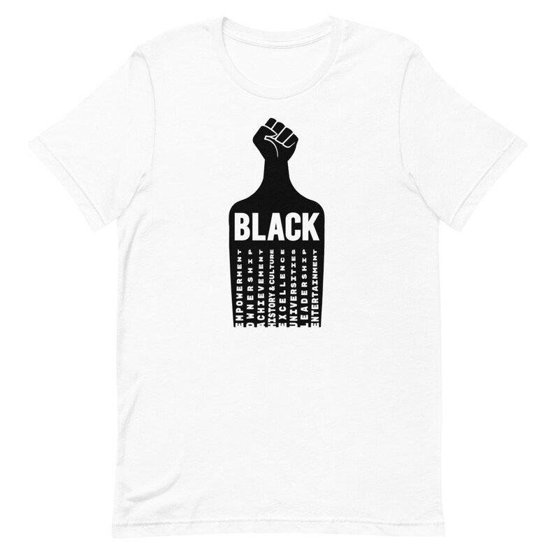 K&ouml;nnte beinhalten: Wei&szlig;es T-Shirt mit einem schwarzen erhobenen Faust-Motiv und dem Wort "BLACK" in gro&szlig;en Buchstaben. Die W&ouml;rter "EMPOWERMENT", "OWNERSHIP", "ACHIEVEMENT", "HISTORY & CULTURE", "EXCELLENCE", "UNIVERSITIES", "LEADERSHIP", "ENTERTAINMENT" sind vertikal unter dem Wort "BLACK" aufgelistet.