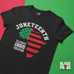 May include: Black t-shirt with a graphic of an American flag in the shape of Africa. The text "Juneteenth Celebrate 1865 Freedom" is printed on the shirt.