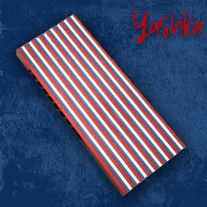 Może przedstawiać: Prostokątny przedmiot z czerwonymi, białymi i niebieskimi pionowymi paskami na tle niebieskiego tła. Słowo "Yashka" jest napisane czerwoną czcionką w prawym górnym rogu.