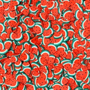 Puede incluir: Primer plano de un montón de rodajas de arcilla polimérica con forma de sandía. Las rodajas son rojas con detalles de semillas negras, acentos de corteza blancos y verdes. Estas piezas decorativas son ideales para manualidades y adornos.