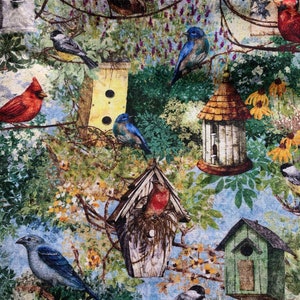 Puede incluir: Una tela colorida con un patr&oacute;n repetitivo de casas para p&aacute;jaros, p&aacute;jaros y flores. Las casas para p&aacute;jaros est&aacute;n pintadas en tonos de verde, marr&oacute;n y amarillo. Los p&aacute;jaros son azules, rojos y marrones. Las flores son amarillas, rosas y moradas.