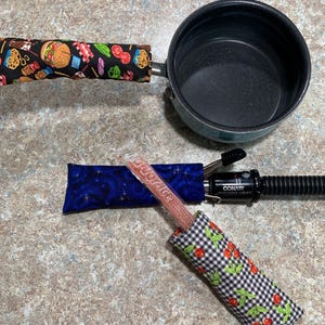 May include: Three fabric pouches with different patterns. The pouches are filled with popsicles. The pouches are on a brown countertop. The text on the popsicle reads "DICE ICE".