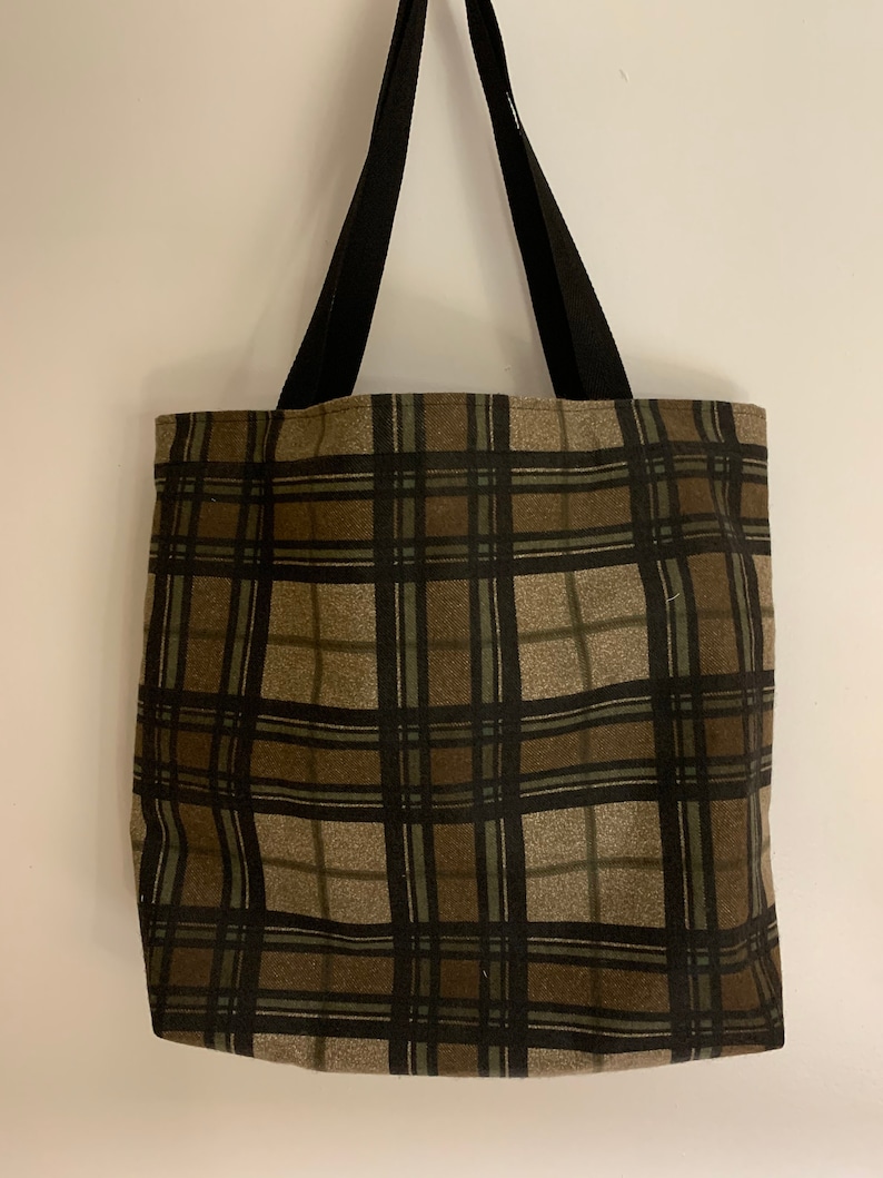 May include: A brown and black plaid tote bag with black straps.