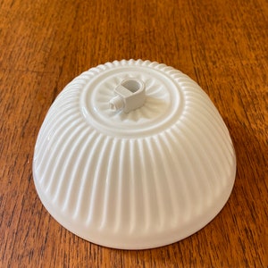 May include: White ceramic ceiling fixture with a ribbed design and a small white plastic hook.