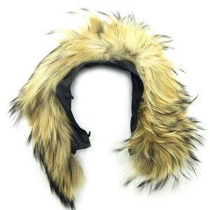 Peut inclure: Une capuche en fausse fourrure noire avec une bordure en fourrure brune et noire. La capuche est doublée de tissu noir et possède un cordon de serrage.