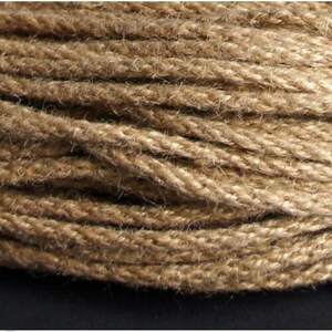 May include: Close-up of a tightly wound, natural brown jute rope. The rope is thick and textured, with visible fibers and a slightly uneven surface. The image highlights the rope's rustic appearance and potential for crafting or decorative use.