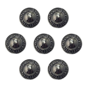 May include: Seven dark grey metal buttons with a raised, textured border and a central, reflective dome. The border features a repeating pattern. These decorative buttons are suitable for various sewing and craft projects.