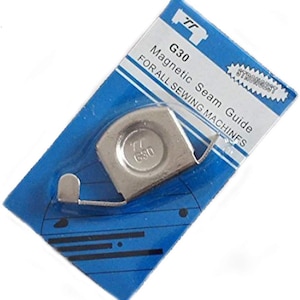 May include: A silver magnetic seam guide for sewing machines. The guide is labelled "G30" and "Strongest" on the blue and white packaging.