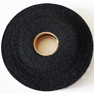 May include: A roll of black, textured tape with a central hole. The tape appears to be made of a fabric-like material, and the core is a light tan color. The tape is circular in shape.