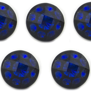 May include: Five circular buttons with a dark base and a bright blue centre. Each button features a central, geometric design surrounded by smaller blue accents. The buttons have a faceted appearance.