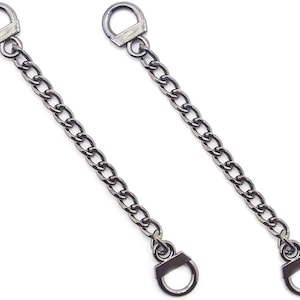 May include: Two black metal chain connectors with D-ring clasps. Each chain is approximately 15 cm long.