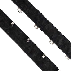 May include: Black velvet ribbon with silver metal hooks. The ribbon is approximately 1 inch wide and has a soft, luxurious feel.