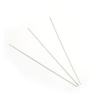 May include: Three thin, silver-colored metal needles are arranged diagonally against a white background. The needles are pointed and appear to be made of a smooth, reflective material. They are likely used for sewing or other craft projects.