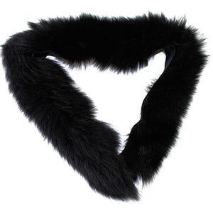 May include: A black faux fur collar, shaped in a loop. The collar is made of soft, fluffy material. The accessory is designed to be worn around the neck. The collar is a solid black color.