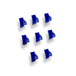 May include: Eight blue state of Rhode Island shaped magnets. The magnets are arranged in a grid pattern on a white background.