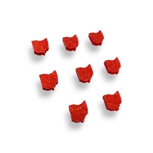 May include: Eight red glitter Ohio state outline shapes scattered on a white background.