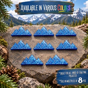 Peut inclure: Huit ornements en forme de montagne à paillettes bleues disposés sur une surface en pierre. Le texte en haut indique "AVAILABLE IN VARIOUS COLORS" et le texte en bas indique "GREAT FOR ALL KINDS OF CRAFTING PROJECTS!" et "SOLD IN MULTIPLES OF 8 PCS".