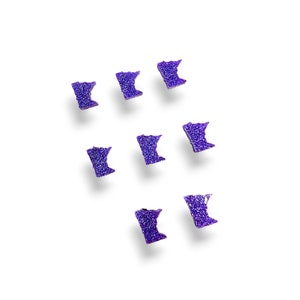 May include: Eight purple glitter Minnesota state outline shapes on a white background.