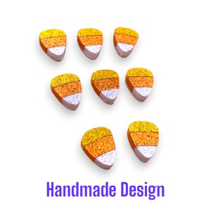 May include: Seven triangular candy corn shaped pieces arranged in three rows. Each piece features three horizontal bands of glittery texture in yellow, orange, and white. The text "Handmade Design" is printed in purple at the bottom of the image.