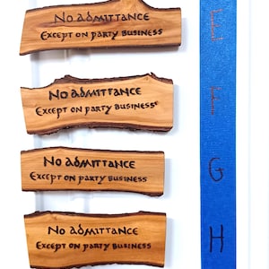 以下が含まれることがあります： スタイリッシュなフォントで「No admittance except on party business」と書かれた木製の看板が6つ。看板は縦に並べられており、青い背景にEからIまでのアルファベットで番号が付けられています。