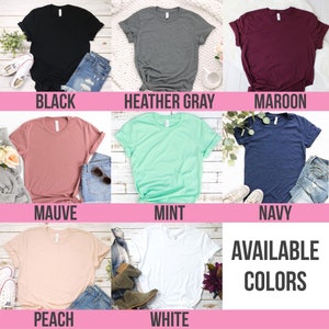 Peut inclure: Pr&eacute;sentation de t-shirts de diff&eacute;rentes couleurs : noir, gris chin&eacute;, bordeaux, mauve, menthe, marine, p&ecirc;che et blanc. Le texte &laquo; AVAILABLE COLORS &raquo; est affich&eacute; dans un encadr&eacute; blanc. Chaque t-shirt est pli&eacute; et pr&eacute;sent&eacute; avec un jean et des accessoires.