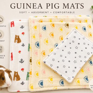 May include: Guinea pig mats in the image are soft, absorbent, and comfortable. One mat is white with bear and mushroom designs, another is yellow with sun patterns, and a smaller one is white with gray stars. The mats are washable and reusable.