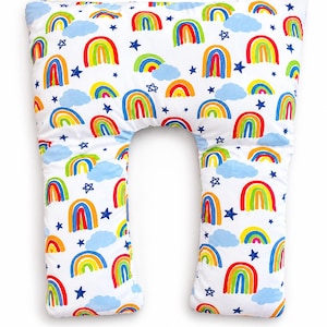 May include: A U-shaped body pillow with a white background and a colourful pattern of rainbows, blue clouds, and blue stars. The rainbows feature red, orange, yellow, green, and blue colours. The pillow is designed for comfort and support.