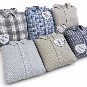 Peut inclure: Plusieurs coussins en forme de chemise, avec différents motifs à carreaux et rayures. Chaque coussin porte un écusson en forme de cœur avec le texte : "This is a shirt I used to wear and when you hold it know I am there."