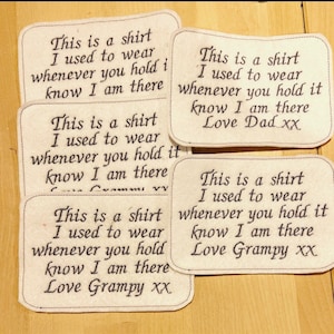 Könnte beinhalten: Vier weiße Stoff-Patches mit schwarzem gesticktem Text. Jeder Patch lautet "This is a shirt I used to wear whenever you hold it know I am there" gefolgt von "Love Dad xx", "Love Grampy xx" oder "Love Grampy xx".