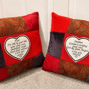 May include: Two red patchwork pillows with heart-shaped embroidered patches. One reads "Paul, I'm still by your side...Love you, NAN XX." The other says "Stephen, Garden's looking good son!...Love you, MUM XX."