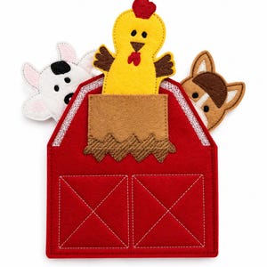 Peut inclure: Une grange rouge en feutre avec une poche marron et des coutures blanches, repr&eacute;sentant une vache, un poulet et un cheval. La vache est blanche avec des taches noires, le poulet est jaune avec une cr&ecirc;te rouge, et le cheval est marron. Un jouet &eacute;ducatif.