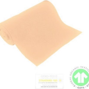 Könnte beinhalten: Eine Rolle peachfarbener Filzstoff. Der Stoff ist nach Oeko-Tex Standard 100 und Global Organic Textile Standard (GOTS) zertifiziert.