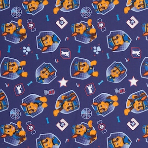 Op de afbeelding: Een blauwe stof met een herhalend patroon van een cartoonhond die een blauw uniform en een politiepet draagt. De hond houdt een megafoon vast en heeft een pootprint op zijn borst. De achtergrond is een blauw en wit rasterpatroon.