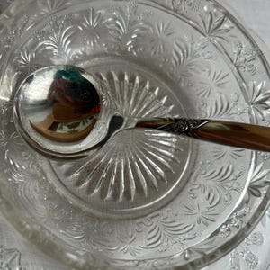 Peut inclure: Un bol et une assiette de service en verre transparent avec une louche en argent. Le bol et l'assiette présentent un motif floral et en forme d'étoile. La louche a un bol en argent et un manche décoratif.
